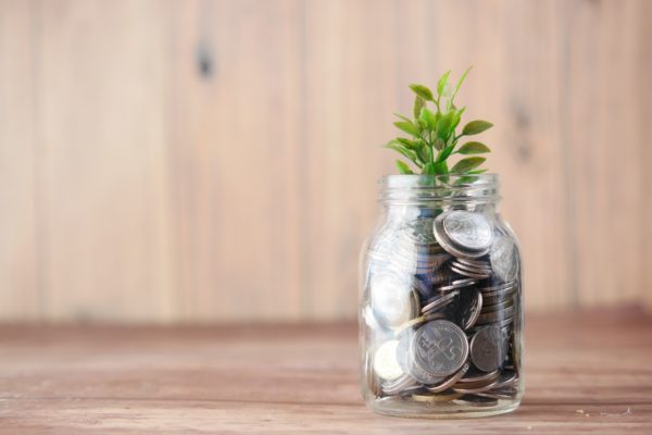 Growing recurring revenue - glass jar with coins and plant